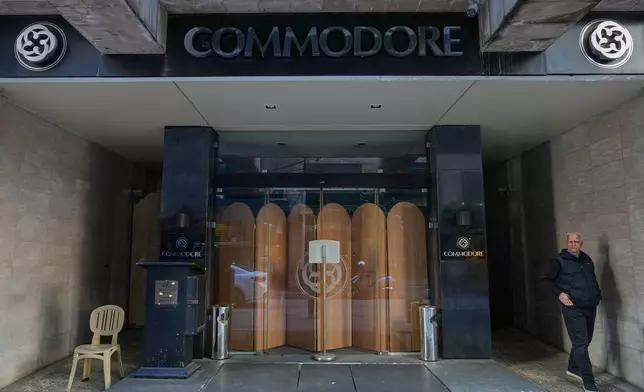 A man stands in the closed main entrance of the Commodore hotel, in Beirut, Lebanon, Sunday, Jan. 11, 2026. (AP Photo/Hussein Malla)