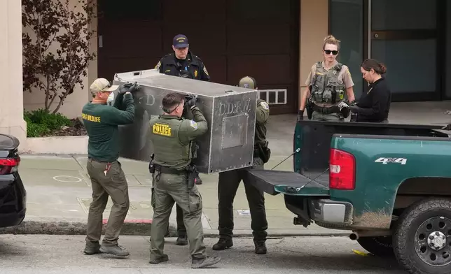 California Fish and Wildlife officials carry a tranquilized mountain lion in a cage after it was captured on Tuesday, Jan. 27, 2026, in San Francisco. (AP Photo/Andy Bao)