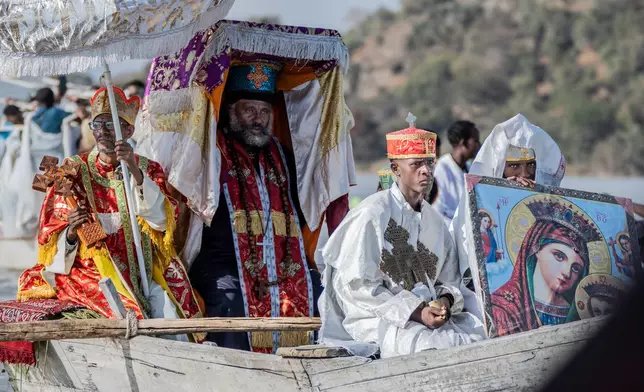 High priests ride in a boat as faithful celebrate Timket, the Ethiopian Epiphany, on lake Dembel, in Batu, Ethiopia, Sunday, Jan. 18, 2026. (AP Photo/Amanuel Sileshi)