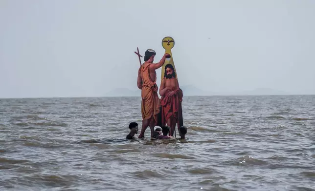 Ethiopian Orthodox devotees place an icon of John the Baptist baptizing Jesus, during the celebration of the Ethiopian Epiphany on the shore of lake Dembel, in Batu, Ethiopia, Monday, Jan. 19, 2026. (AP Photo/Amanuel Sileshi)