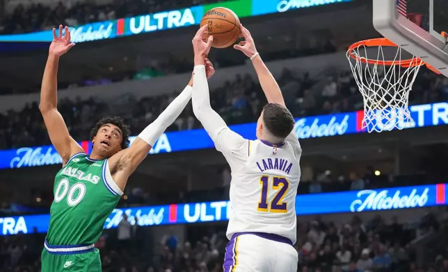 Los Angeles Lakers forward Jake LaRavia (12) reaches for a pass as Dallas Mavericks guard Max Christie (00) defends during the first half of an NBA basketball game Saturday, Jan. 24, 2026, in Dallas. (AP Photo/Julio Cortez)
