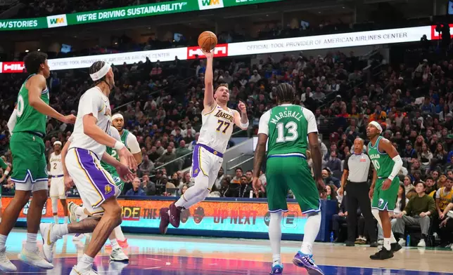 Los Angeles Lakers guard Luka Doncic (77) throws up a shot against Dallas Mavericks forward Naji Marshall (13) during the first half of an NBA basketball game Saturday, Jan. 24, 2026, in Dallas. (AP Photo/Julio Cortez)