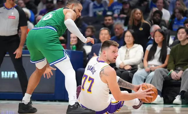 Los Angeles Lakers guard Luka Doncic (77) controls the ball against Dallas Mavericks forward Caleb Martin during the first half of an NBA basketball game Saturday, Jan. 24, 2026, in Dallas. (AP Photo/Julio Cortez)