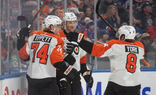 Philadelphia Flyers' Owen Tippett (74), Denver Barkey (52), Sean Couturier (14) and Cam York (8) celebrate a goal against the Edmonton Oilers during the first period of an NHL hockey game, in Edmonton, Saturday, Jan. 3, 2026. (Jason Franson/The Canadian Press via AP)