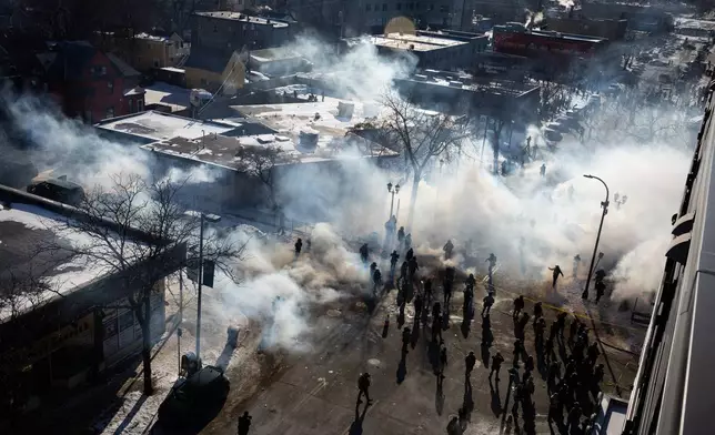 Federal agents deploy tear gas and other munitions into a crowd of people near the intersection of 27th Street and Nicollet Avenue in Minneapolis after a federal officer shot and killed 37-year-old Alex Pretti on Saturday, Jan. 24, 2026. (Ben Hovland/Minnesota Public Radio via AP)