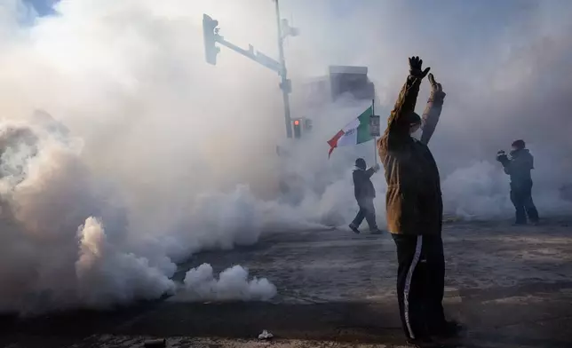 A person holds up their hands as law enforcement deploys a thick screen of teargas on Nicollet Avenue in Minneapolis on Saturday, Jan. 24, 2026. (Ben Hovland/Minnesota Public Radio via AP)