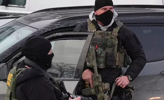 Federal immigration agents work on the scene in Minneapolis, Sunday, Jan. 25, 2026. (AP Photo/Adam Gray)