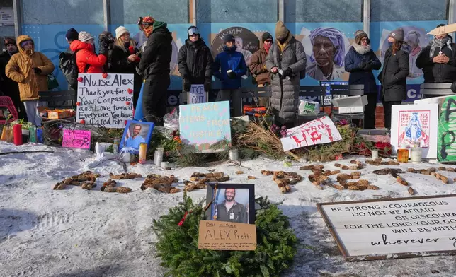 People gather near the scene where Alex Pretti was fatally shot by a U.S. Border Patrol officer yesterday, in Minneapolis, Sunday, Jan. 25, 2026. (AP Photo/Adam Gray)