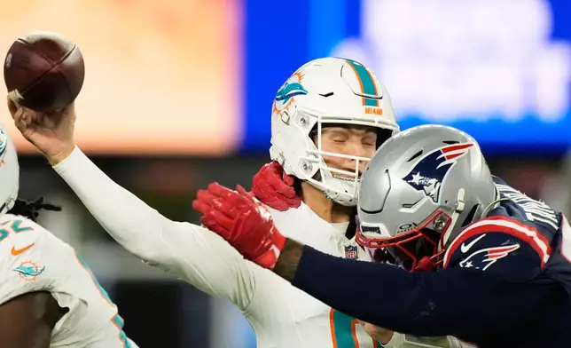 Miami Dolphins quarterback Zach Wilson, left, is tackled by New England Patriots linebacker Jahlani Tavai during the second half of an NFL football game in Foxborough, Mass., Sunday, Jan. 4, 2026. (AP Photo/Robert F. Bukaty)