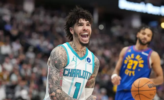 Charlotte Hornets guard LaMelo Ball reacts after dunking the ball for a basket as Denver Nuggets guard Jamal Murray looks on in the second half of an NBA basketball game Sunday, Jan. 18, 2026, in Denver. (AP Photo/David Zalubowski)