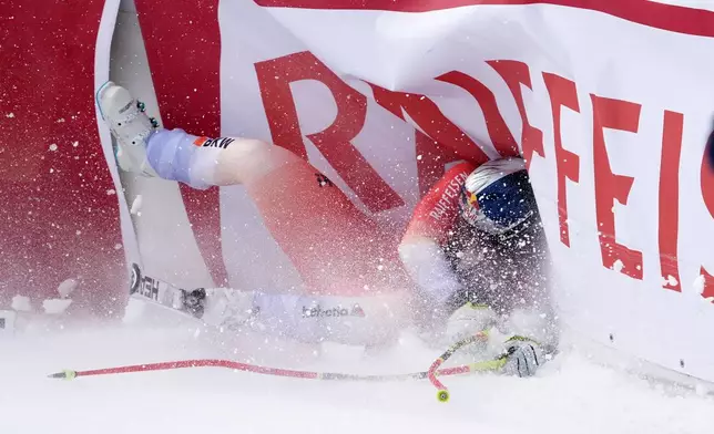 Switzerland's Franjo von Allmen crashes at the finish area of an alpine ski, men's World Cup downhill, in Wengen, Switzerland, Saturday, Jan. 17, 2026. (AP Photo/Giovanni Zenoni)