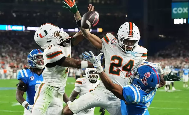 Miami safety Zechariah Poyser (7) and defensive back Ethan O'Connor (24) break up a pass intended for Mississippi wide receiver De'zhaun Stribling (1) during the second half the Fiesta Bowl NCAA college football playoff semifinal game, Thursday, Jan. 8, 2026, in Glendale, Ariz. (AP Photo/Ross D. Franklin)