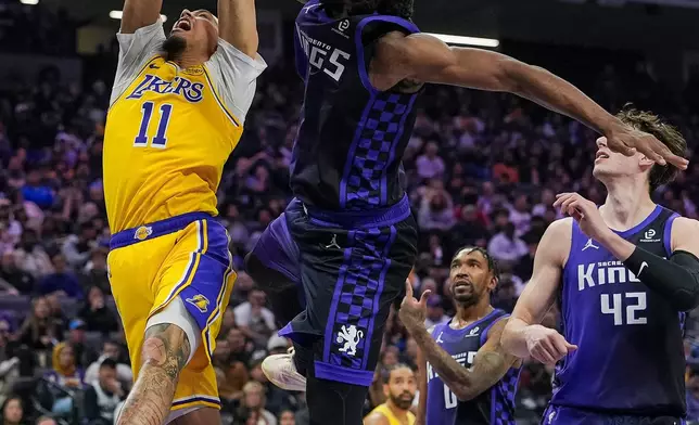 Sacramento Kings forward Precious Achiuwa, second from left, blocks a shot by Los Angeles Lakers center Jaxson Hayes (11) during the first half of an NBA basketball game, Monday, Jan. 12, 2026, in Sacramento, Calif. (AP Photo/Justine Willard)