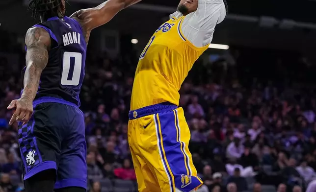 Los Angeles Lakers center Jaxson Hayes, righht, goes up to dunk over Sacramento Kings guard Malik Monk (0) during the first half of an NBA basketball game, Monday, Jan. 12, 2026, in Sacramento, Calif. (AP Photo/Justine Willard)