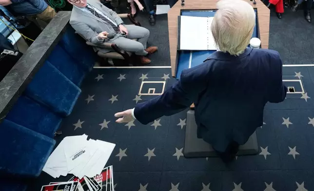Documents are seen on the ground after President Donald Trump displayed them during a press briefing at the White House in Washington, Tuesday, Jan. 20, 2026. (AP Photo/Mark Schiefelbein)