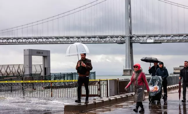 People shield themselves from the rain Saturday, Jan. 3, 2026, in San Francisco. (Yalonda M. James/San Francisco Chronicle via AP)