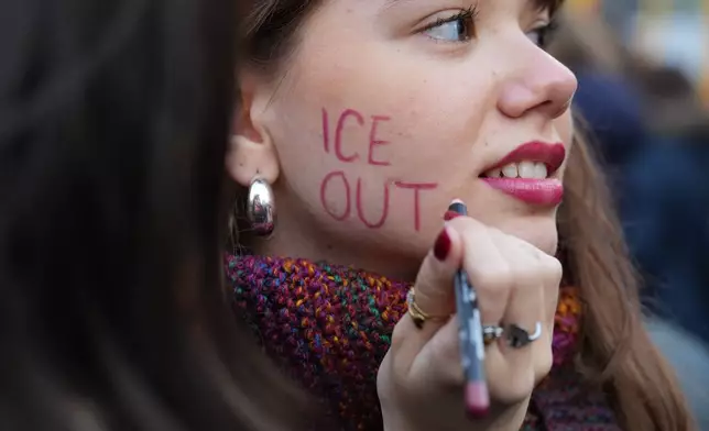 A person takes part in an Anti-ICE demonstration, ahead of the 2026 Winter Olympics, in Milan, Italy, Saturday, Jan. 31, 2026. (AP Photo/Antonio Calanni)