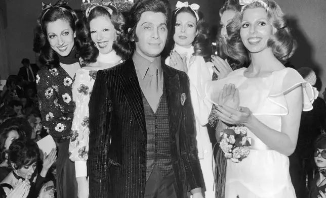 FILE - Models join the public in clapping hands as they flank Italian fashion designer Valentino Garavani at the end of the show of his spring-summer collection in Rome, Italy on Jan. 20, 1971. (AP Photo/Gianni Foggia, File)