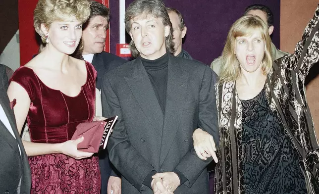 FILE - Princess Diana, left, wearing a gown designed by Valentino Garavani, stands next to British singer and former Beatle Paul McCartney and his wife, Linda, as they arrive at the Music Palace in Lille, France, Nov. 15, 1992. (AP Photo/Lionel Cironneau, File)
