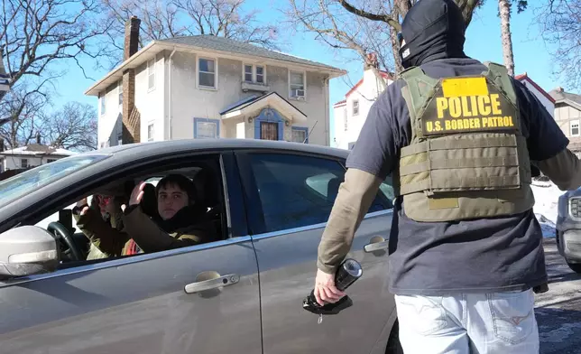 A federal agent approaches a vehicle on Thursday, Jan. 29, 2026, in Minneapolis. (AP Photo/Adam Gray)