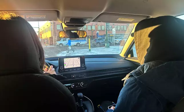 A pair of volunteer observers patrol south Minneapolis neighborhoods Tuesday, Jan 27, 2026, looking for signs of activity by federal immigration officers. (AP Photo/Tim Sullivan)