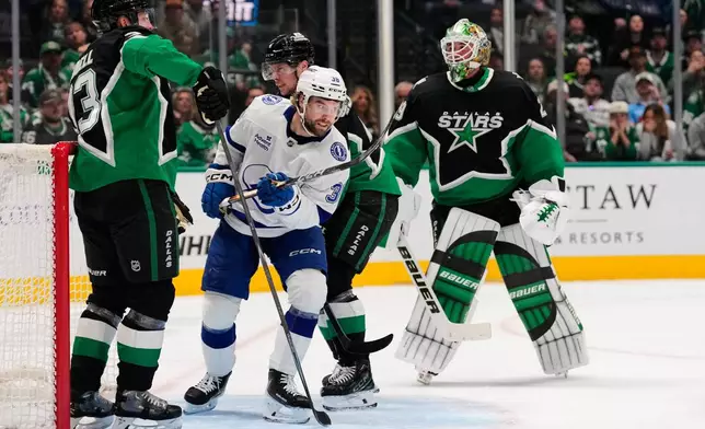 Tampa Bay Lightning left wing Brandon Hagel celebrates his core as Dallas Stars' Esa Lindell, left, Miro Heiskanen, rear, and Jake Oettinger (29) look on in the second period of an NHL hockey game in Dallas, Sunday, Jan. 18, 2026. (AP Photo/Tony Gutierrez)