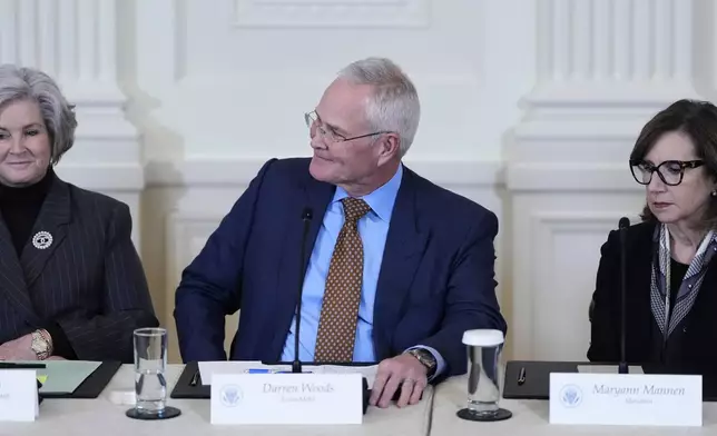 Chief Executive Officer and Chairman of ExxonMobil Darren Woods greets President Donald Trump, not pictured, with White House Chief of Staff Susie Wiles, seated left, and Chairman, President and Chief Executive Officer of Marathon Petroleum Maryann Mannen, seated right, during a meeting in the East Room of the White House, Friday, Jan. 9, 2026, in Washington. (AP Photo/Alex Brandon)