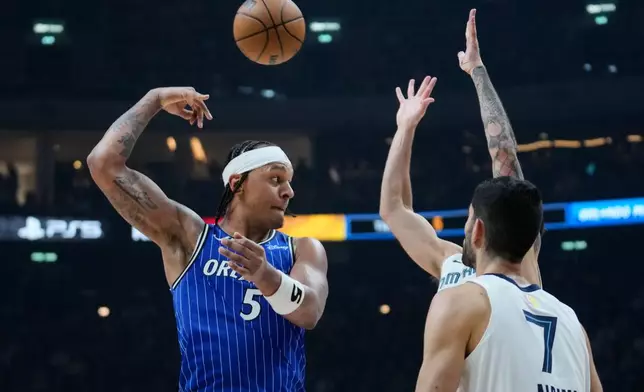 Orlando Magic forward Paolo Banchero (5) passes the ball during an NBA basketball game between Orlando Magic and Memphis Grizzlies in Berlin, Germany, Thursday, Jan. 15, 2026. (AP Photo/Ebrahim Noroozi)