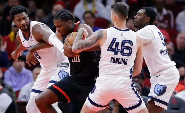 Houston Rockets center Clint Capela, second from left, tries to get past Memphis Grizzlies forward Jaren Jackson Jr. (8), guard John Konchar (46) and guard Vince Williams Jr. (5) who try to strip the ball away from him during the first half of an NBA basketball game Monday, Jan. 26, 2026, in Houston. (AP Photo/Michael Wyke)