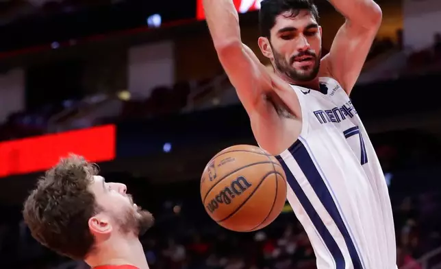 Memphis Grizzlies forward Santi Aldama (7) dunks the ball over Houston Rockets center Alperen Sengun (28) during the first half of an NBA basketball game Monday, Jan. 26, 2026, in Houston. (AP Photo/Michael Wyke)