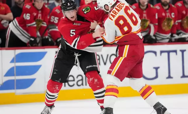 Chicago Blackhawks defenseman Connor Murphy (5), left, and Calgary Flames left wing Joel Farabee (86) fight during the second period of an NHL hockey game, Thursday, Jan. 15, 2026, in Chicago. (AP Photo/Erin Hooley)