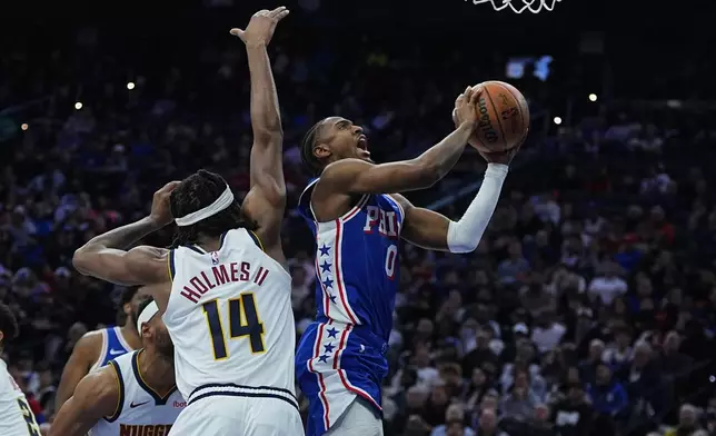 Philadelphia 76ers' Tyrese Maxey (0) goes up to shoot against Denver Nuggets' Daron Holmes II during the first half of an NBA basketball game Monday, Jan. 5, 2026, in Philadelphia. (AP Photo/Matt Rourke)