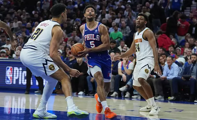 Philadelphia 76ers' Quentin Grimes (5) goes up to shoot against Denver Nuggets' Spencer Jones (21) and Jalen Pickett (24) during the first half of an NBA basketball game Monday, Jan. 5, 2026, in Philadelphia. (AP Photo/Matt Rourke)