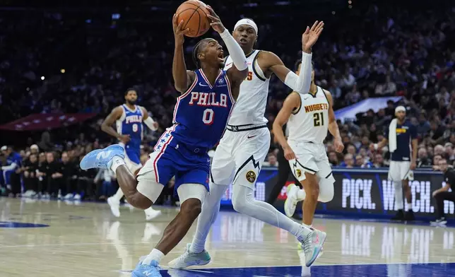 Philadelphia 76ers' Tyrese Maxey (0) goes up to shoot against Denver Nuggets' Peyton Watson during the first half of an NBA basketball game Monday, Jan. 5, 2026, in Philadelphia. (AP Photo/Matt Rourke)