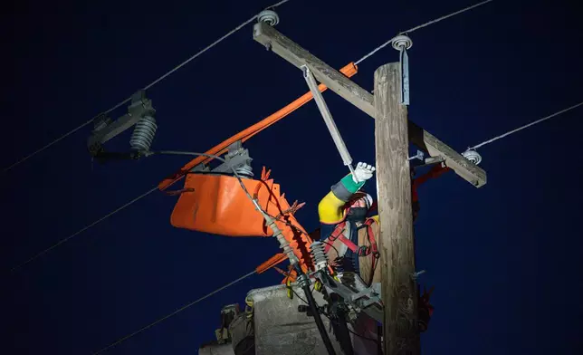 FILE - Oncor apprentice lineman Brendan Waldon repairs a utility pole that was damaged by a winter storm on Feb. 18, 2021, in Odessa, Texas. (Eli Hartman/Odessa American via AP, File)