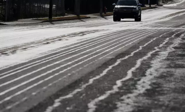 A motorist travels on a road that has been treated with salt brine Thursday, Jan. 22, 2026, in Nashville, Tenn. ahead of a winter storm expected to hit the state over the weekend. (AP Photo/George Walker IV)