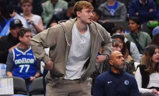 Injured Dallas Mavericks forward Cooper Flagg watches from the bench during the first half of an NBA basketball game against the Utah Jazz in Dallas, Thursday, Jan. 15, 2026. (AP Photo/LM Otero)