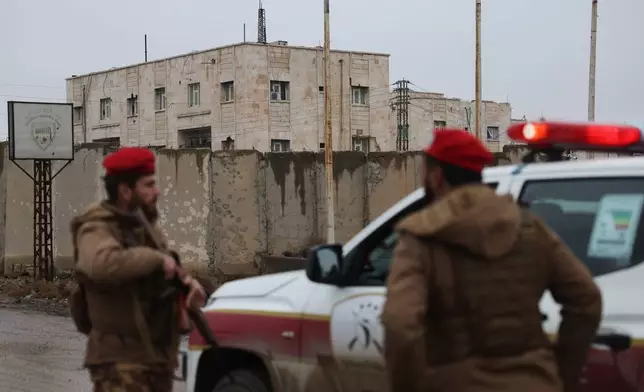 Syrian government forces stand guard at the al-Aqtan prison after taking control of it from the Kurdish-led Syrian Democratic Forces, SDF, in Raqqa, northeastern Syria, Friday, Jan. 23, 2026. (AP Photo/Ghaith Alsayed)