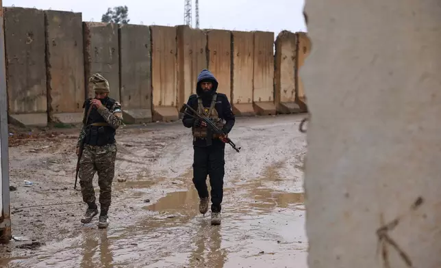Syrian government forces walk in the al-Aqtan prison after taking control of it from the Kurdish-led Syrian Democratic Forces, SDF, in Raqqa, northeastern Syria, Friday, Jan. 23, 2026. (AP Photo/Ghaith Alsayed)