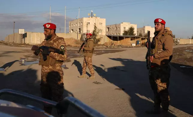Syrian government forces stand guard outside Al-Aqtan prison on the outskirts of Raqqa, northeastern Syria, Monday, Jan. 19, 2026, as negotiations are underway between the Syrian government and the Kurdish-led Syrian Democratic Forces over a withdrawal from the prison. (AP Photo/Omar Albam)