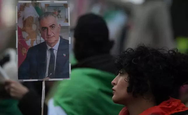 Police stand guard during a protest outside the Iranian Embassy in London, Monday, Jan. 12, 2026. (AP Photo/Alastair Grant)