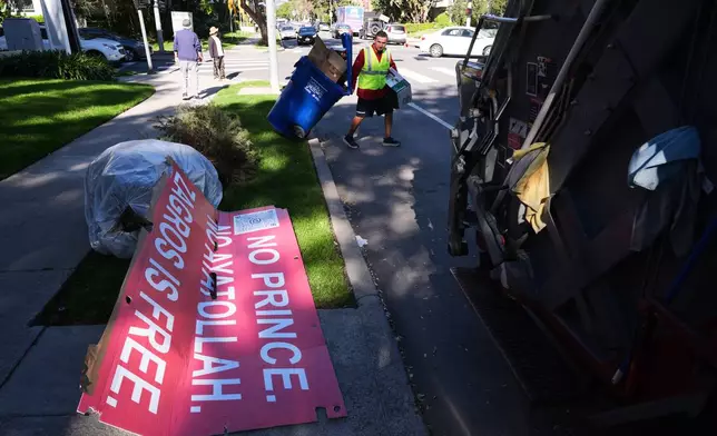 Signs from a Sunday protest, supporting protesters in Iran, are left on a sidewalk Monday, Jan. 12, 2026, in Los Angeles. (AP Photo/Damian Dovarganes)