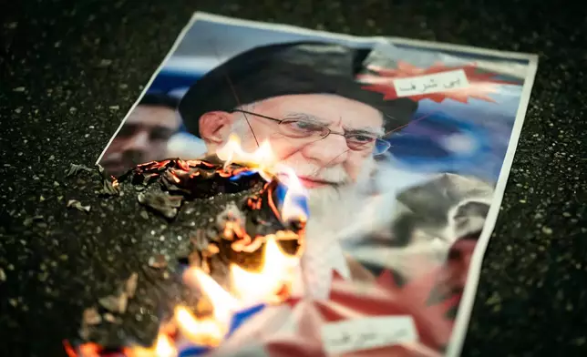A buring image of the Ayatollah Ali Khamenei is seen during rally in support of the nationwide mass demonstrations in Iran against the government, Tuesday, Jan. 13, 2026 in Zuerich, Switzerland.(Michael Buholzer /Keystone via AP)