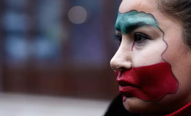A woman, with her face painted with the colors of Iran's flag, joins with others during a small demonstration, in Istanbul, Sunday, Jan. 11, 2026, in support of the nationwide mass protests in Iran against the government. (AP Photo/Emrah Gurel)