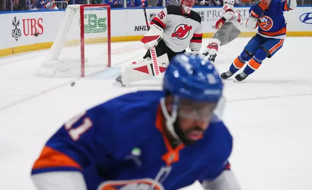 New Jersey Devils goaltender Jacob Markstrom (25) watchs New York Islanders' Anthony Duclair (11) after Duclair scored a goal during the first period of an NHL hockey game Tuesday, Jan. 6, 2026, in Elmont, N.Y. (AP Photo/Frank Franklin II)