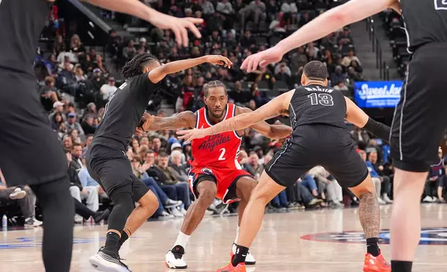 Los Angeles Clippers forward Kawhi Leonard (2) is defended by Brooklyn Nets forward Tyrese Martin (13) and forward Ziaire Williams (1) during the second half of an NBA basketball game Sunday, Jan. 25, 2026, in Inglewood, Calif. (AP Photo/Jae C. Hong)