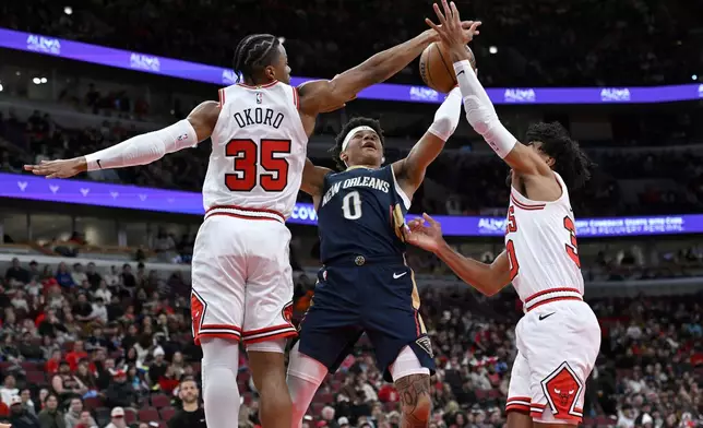 New Orleans Pelicans' Jeremiah Fears (0) goes up for a shot against Chicago Bulls' Isaac Okoro (35) and Tre Jones (30) during the first half of an NBA basketball game, Wednesday, Dec. 31, 2025, in Chicago. (AP Photo/Paul Beaty)