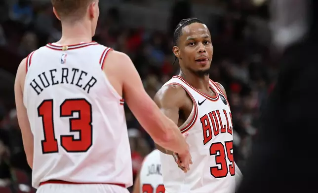 Chicago Bulls' Isaac Okoro (35) celebrates with teammate Kevin Huerter (13) during the final seconds of an NBA basketball game against the New Orleans Pelicans, Wednesday, Dec. 31, 2025, in Chicago. (AP Photo/Paul Beaty)