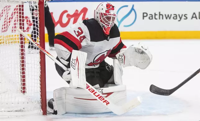 New Jersey Devils goalie Jake Allen (34) looks for the puck against the Edmonton Oilers during the second period of an NHL hockey game in Edmonton on Tuesday, Jan. 20, 2026. (Jason Franson/The Canadian Press via AP)