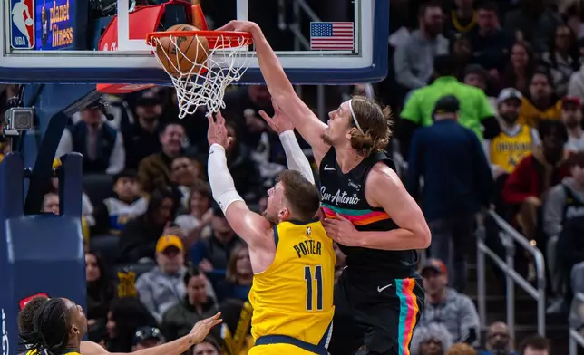 San Antonio Spurs forward Kelly Olynyk, right, scores over the top of Indiana Pacers center James Wiseman (11) during the first half of an NBA basketball game in Indianapolis, Friday, Jan. 2, 2026. (AP Photo/Doug McSchooler)